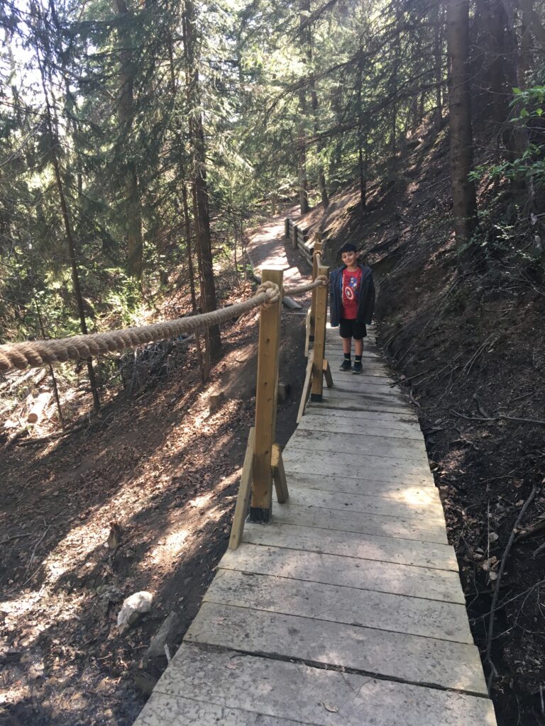 Boy smiles for photo on the Douglas Fir Trail in Edworthy Park in Calgary.