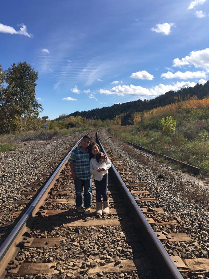 Children posing on train tracks in Edworthy Park in Calgary.