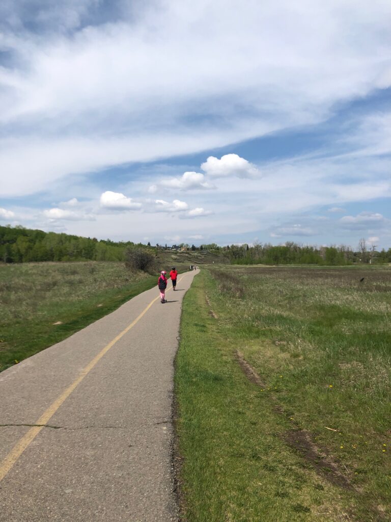 Children scootering on path in Fish Creek Provincial Park in Calgary.