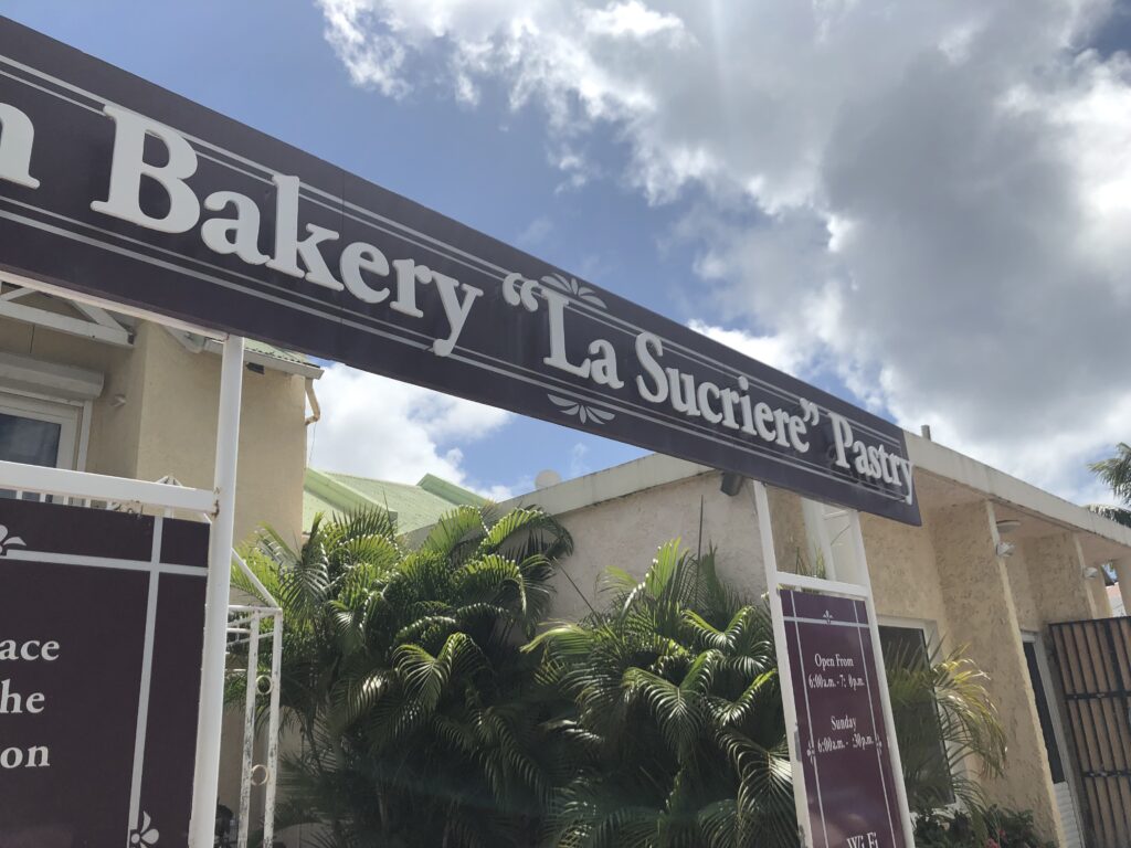 Large brown sign with name of bakery displayed over entrance.