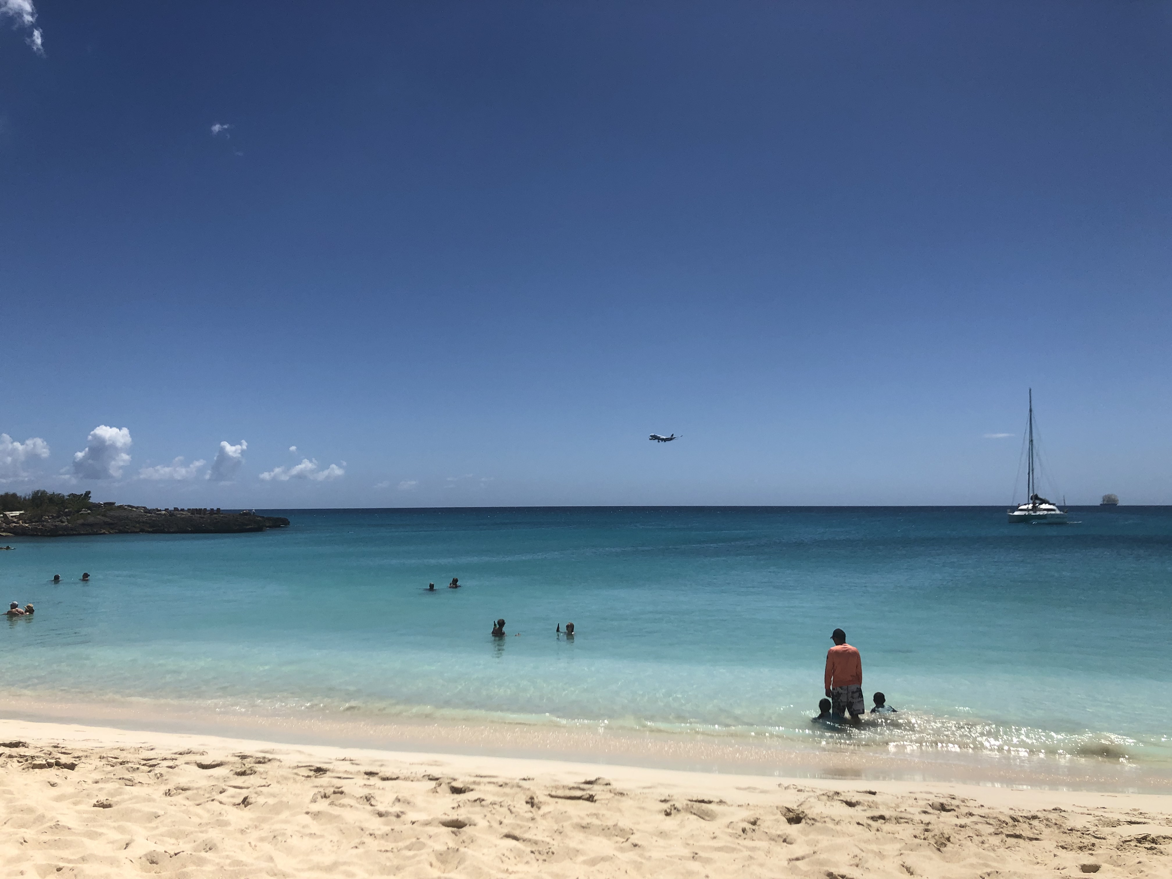 Plane coming in to land from a distance over Caribbean Sea.