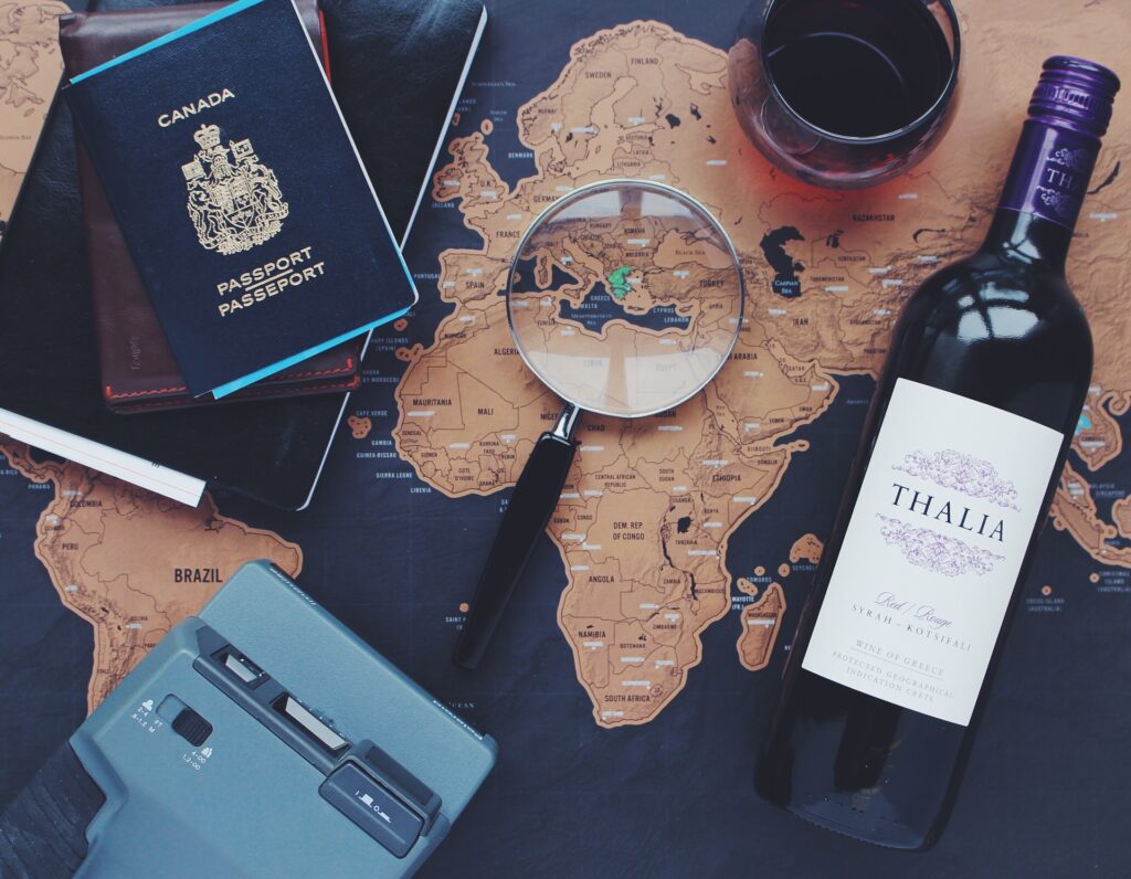 Items such as a passport, map, and magnifying glass that could be used to prepare a travel bucket list.