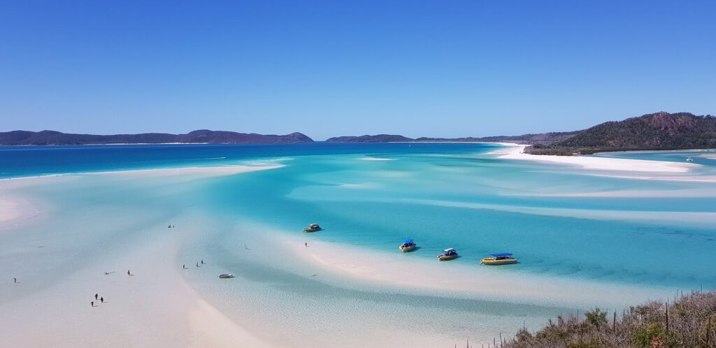 White sand and aqua water swept across the landscape in the travel bucket list setting of the Whitsunday Islands.