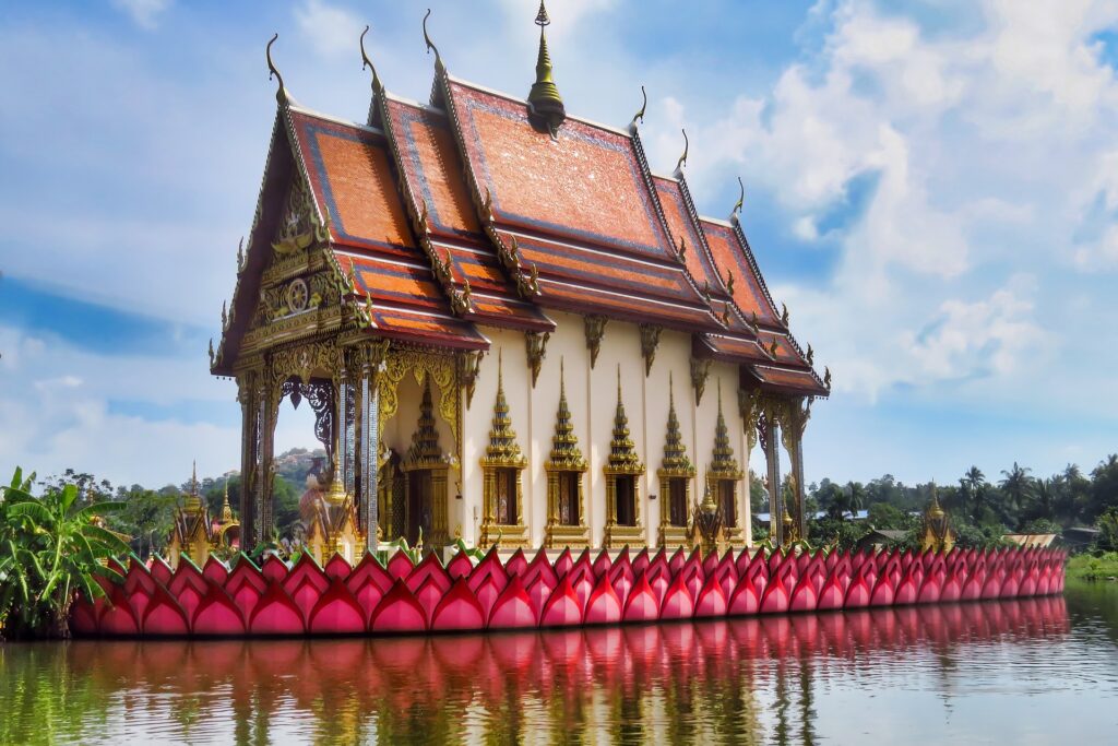 An intricate temple sitting next to a lake to look as if it is floating.