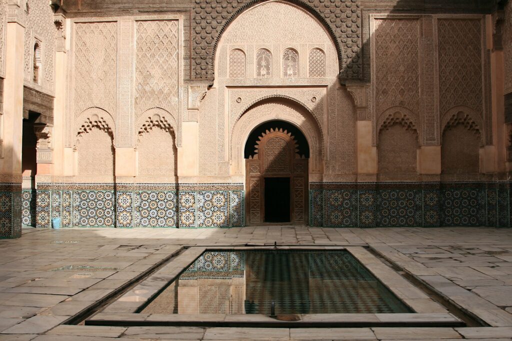 Moroccan courtyard with reflecting pool in foreground.