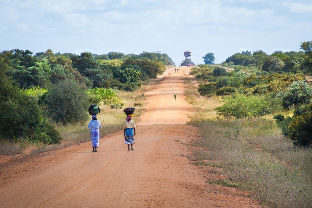 African women walking along a sand road in Mozambique.