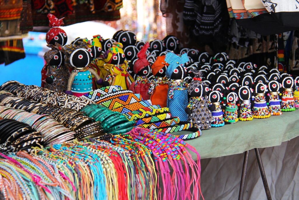 Colorful bracelets, bangles and dolls on a craft table in Africa.