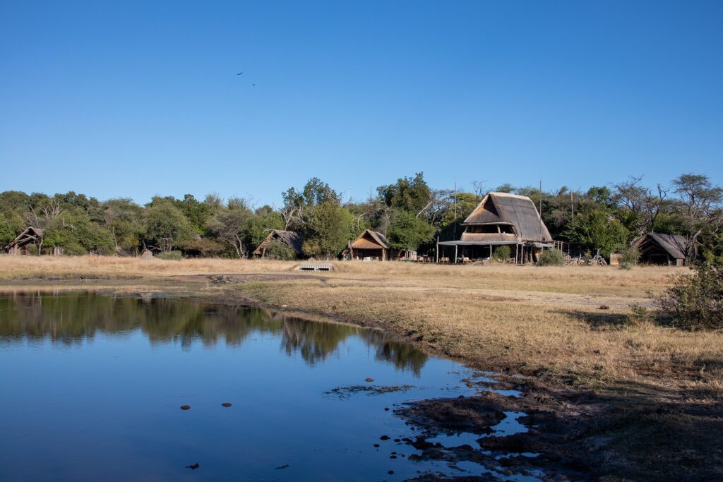 African homes next to a slew-like lake in Africa.