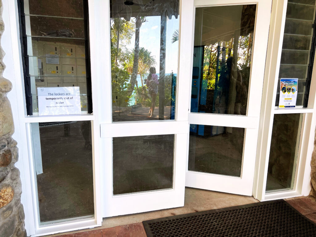 Glass doors with white trim leading inside a locker room.