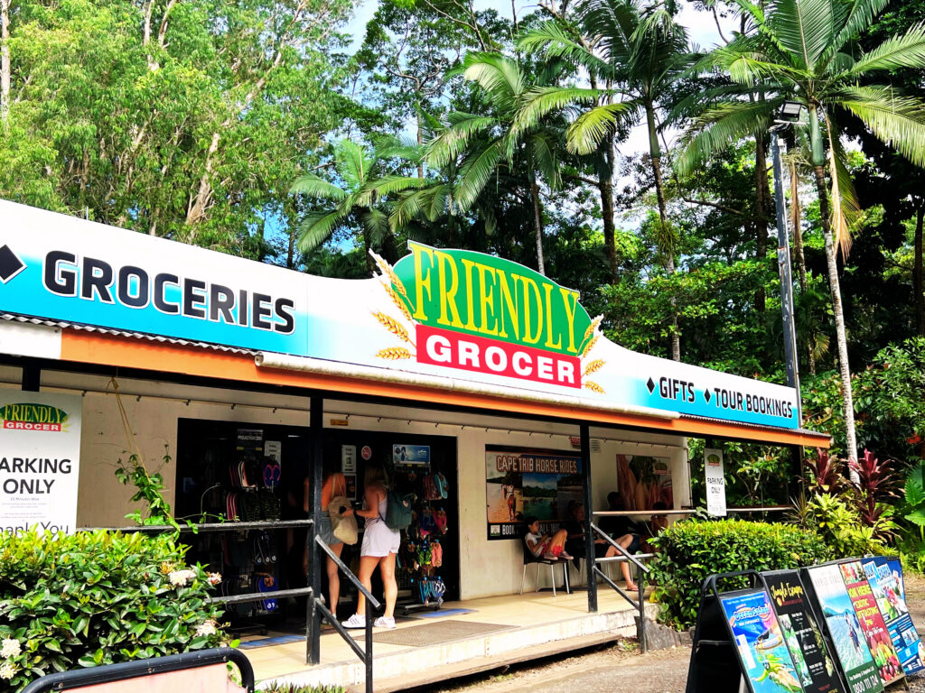 Exterior of convenience shop with sign saying they sell groceries, gifts and tour bookings.