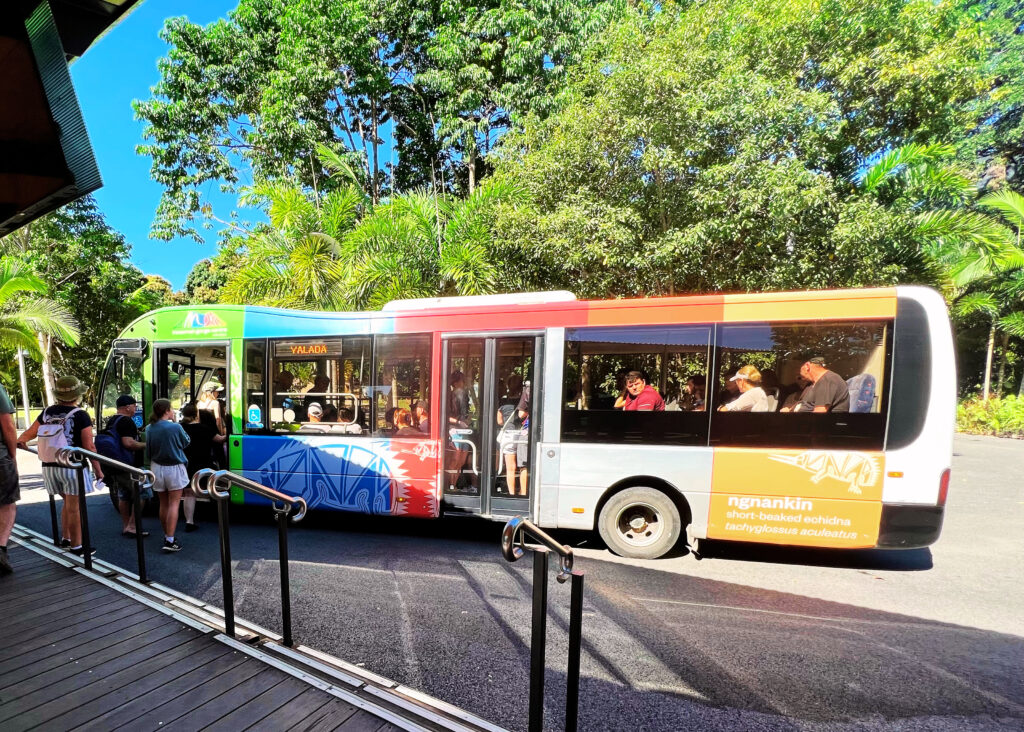 People boarding a colorful shuttle bus to Mossman Gorge.