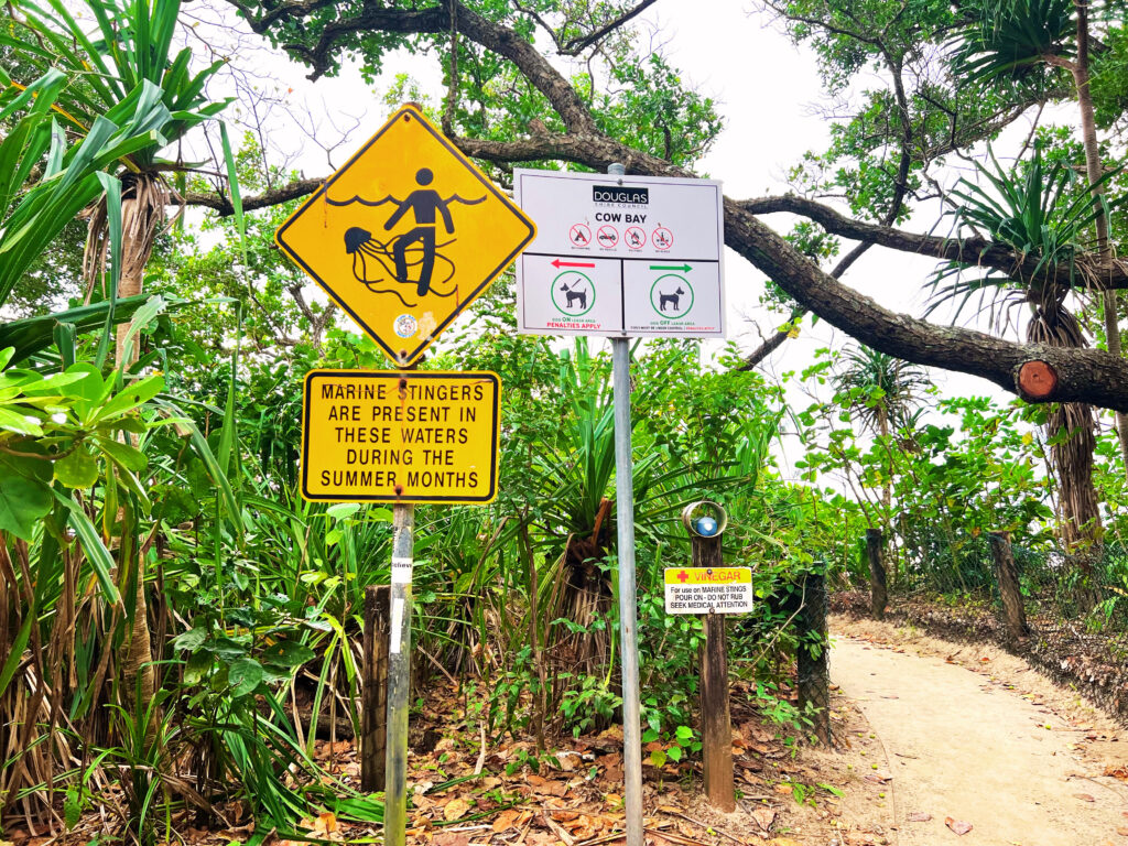 Warning signs at entrance of Cow Bay Beach.