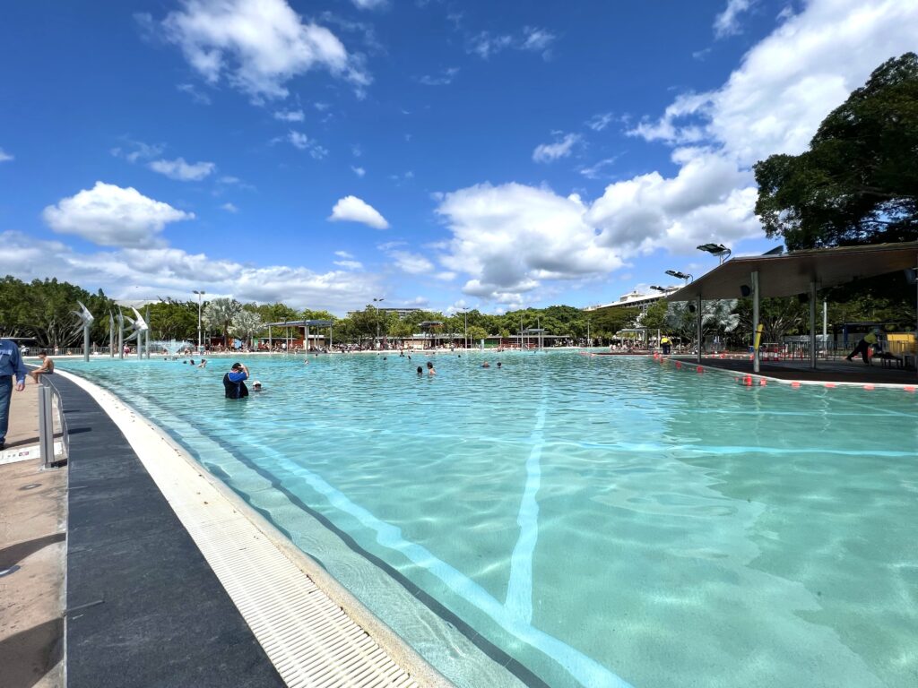 Swimmers cooling off in a large outdoor pool.