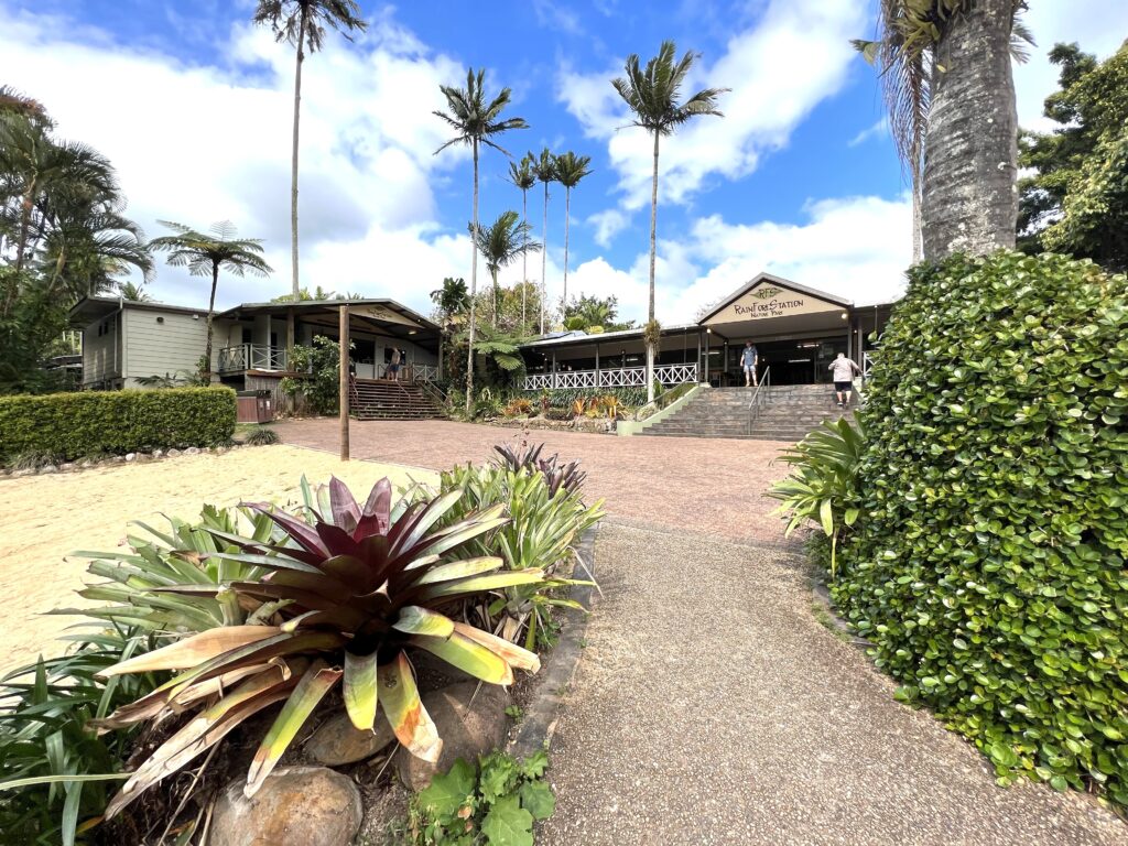 Building for nature park with tall palm trees and green flora and fauna around it.