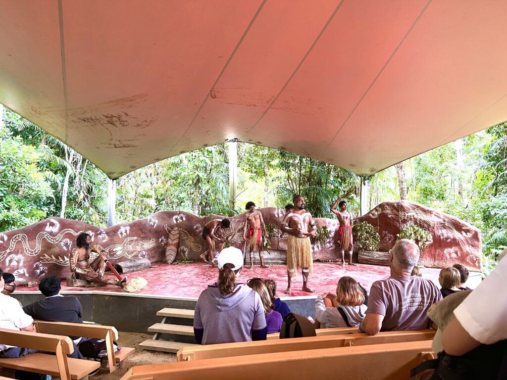 Looking at the stage of an outdoor amphitheatre with Australian aboriginals performing.