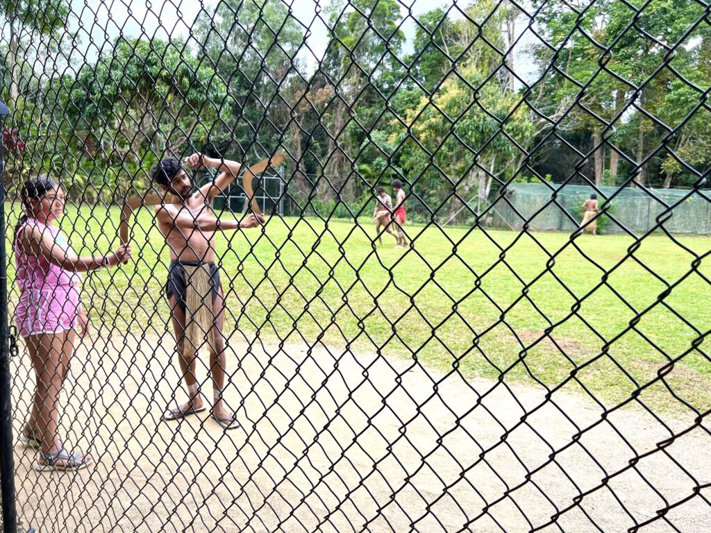 Australian aboriginal showing a girl how to throw a boomerang, a fun thing to do during 5 days in Tropical North Queensland.