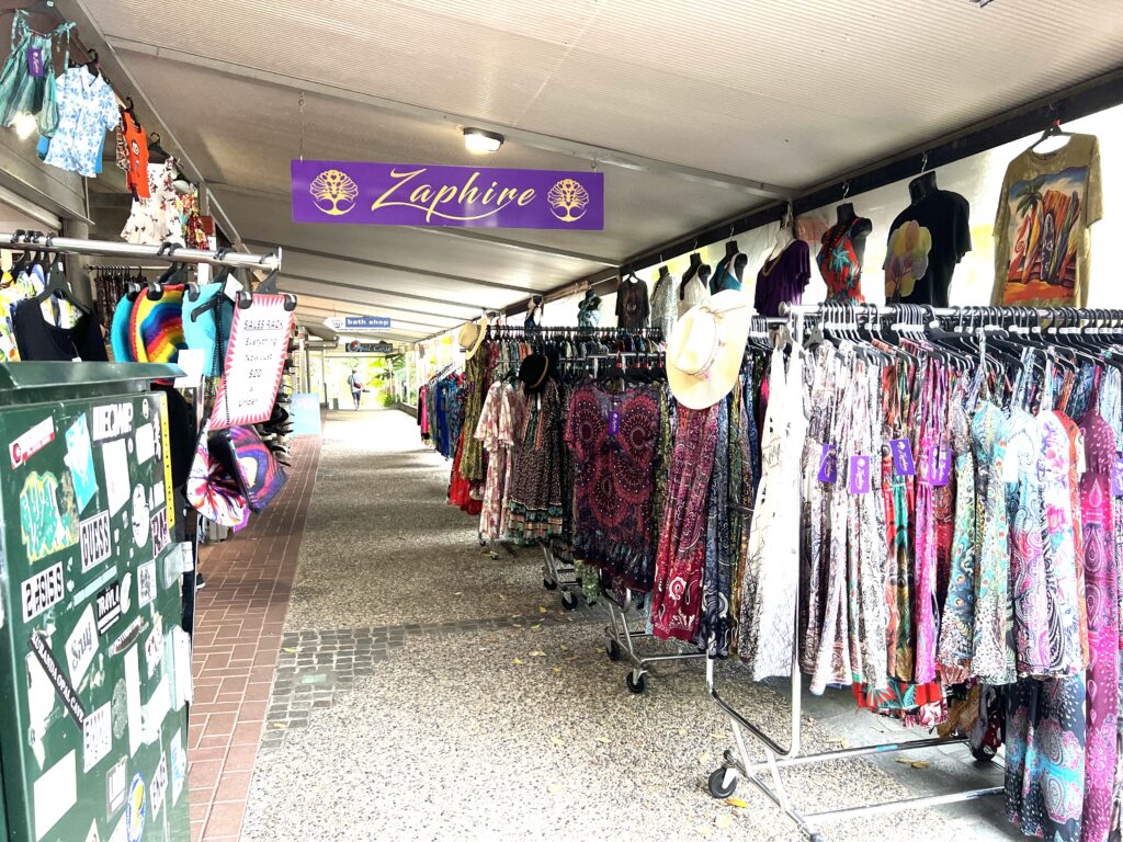 Colorful clothes hanging on lined-up racks on display.