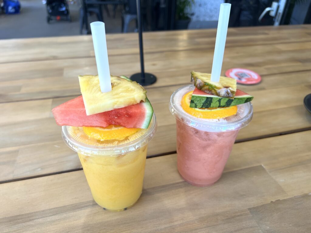 Close up of two smoothies sitting on a table.