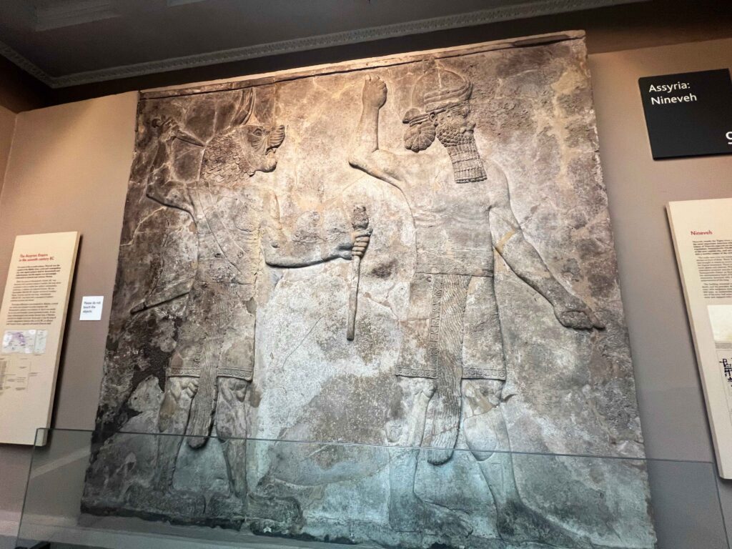 Intricate Assyrian carving displayed in British Museum.