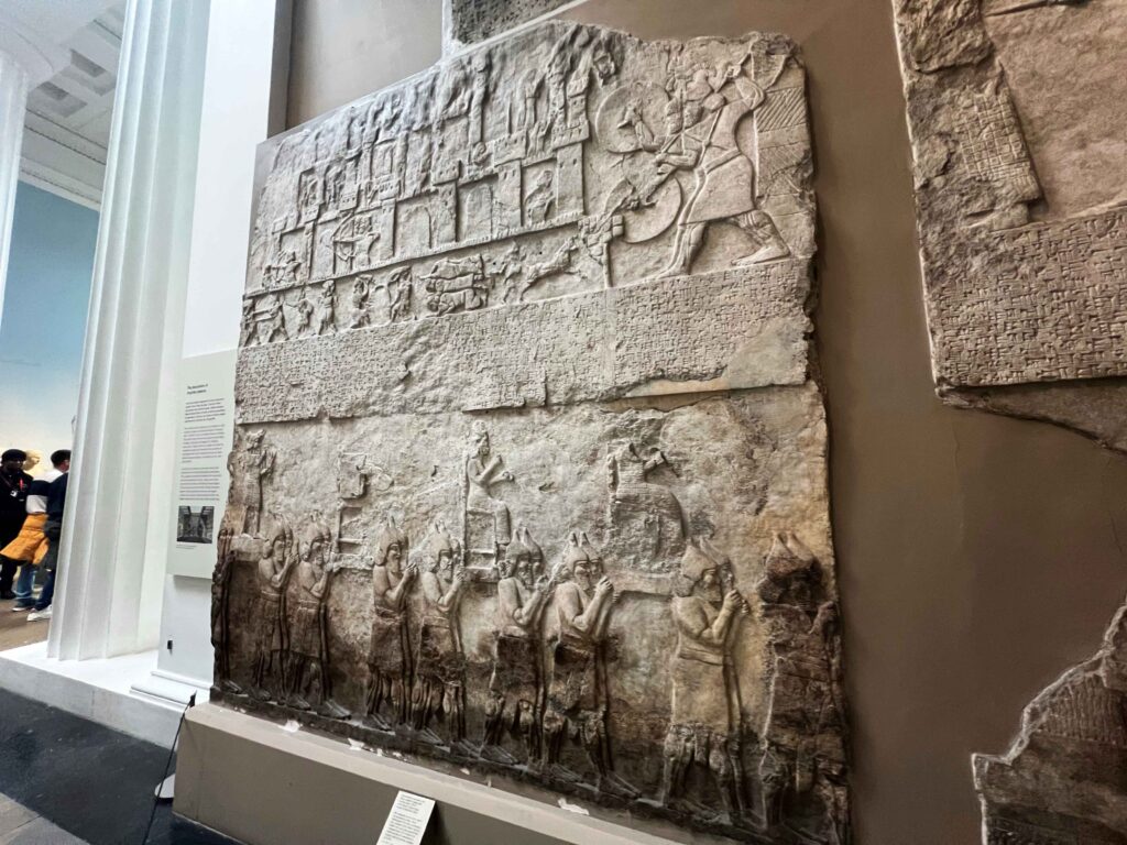 Intricate Assyrian carving displayed in British Museum.