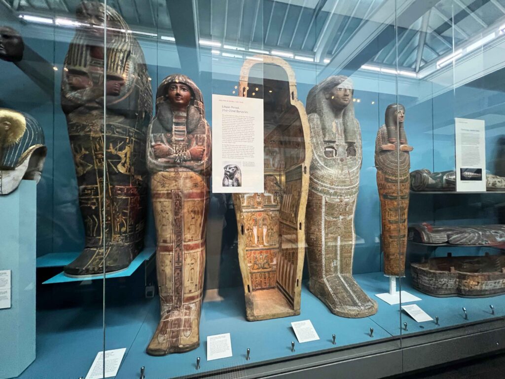A display case housing standing mummies in the British Museum.