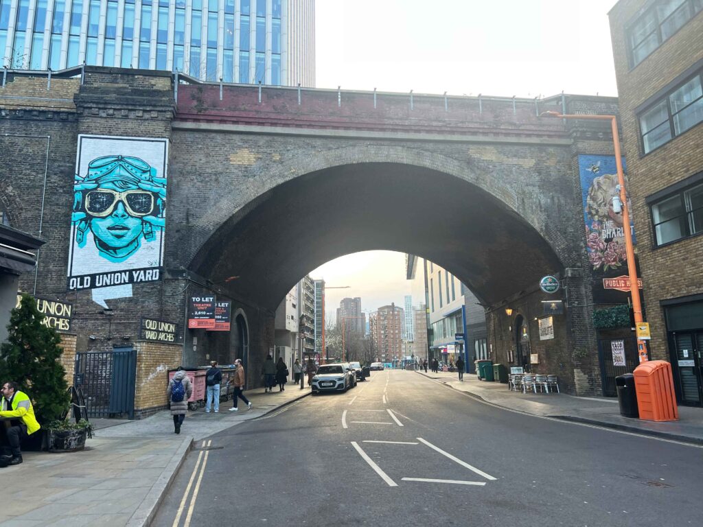 An old overpass stretching over a road in London.