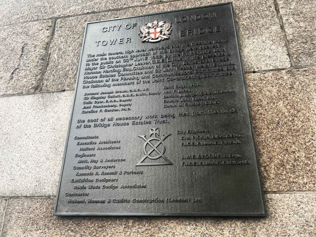 A memorial plaque attached to a stone tower.