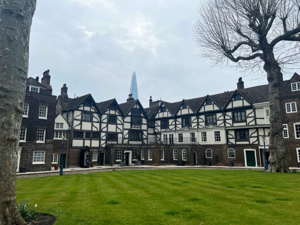Ancient townhomes built around a green lawn in the Tower of London