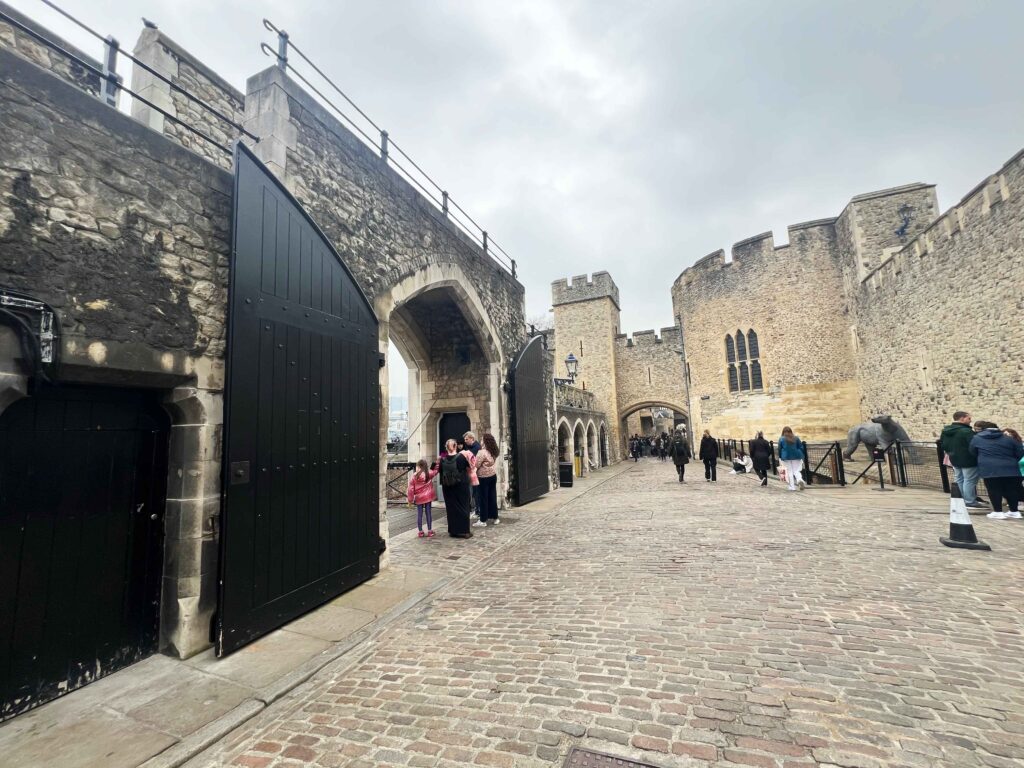 The massive gates in a tall stone exterior wall.