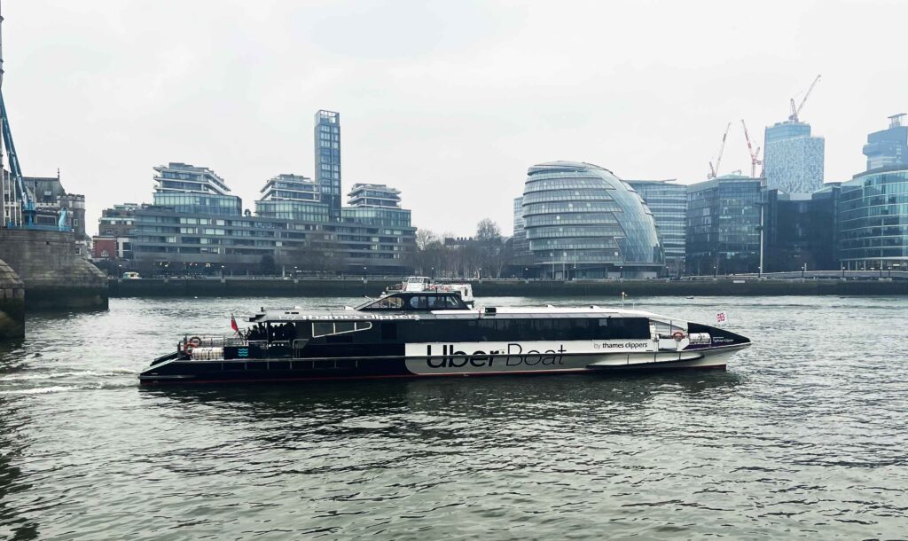 A long Uber passenger boat on the River Thames.