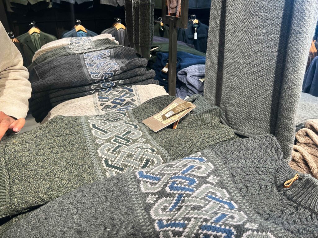 Handmade sweaters folded on a table.