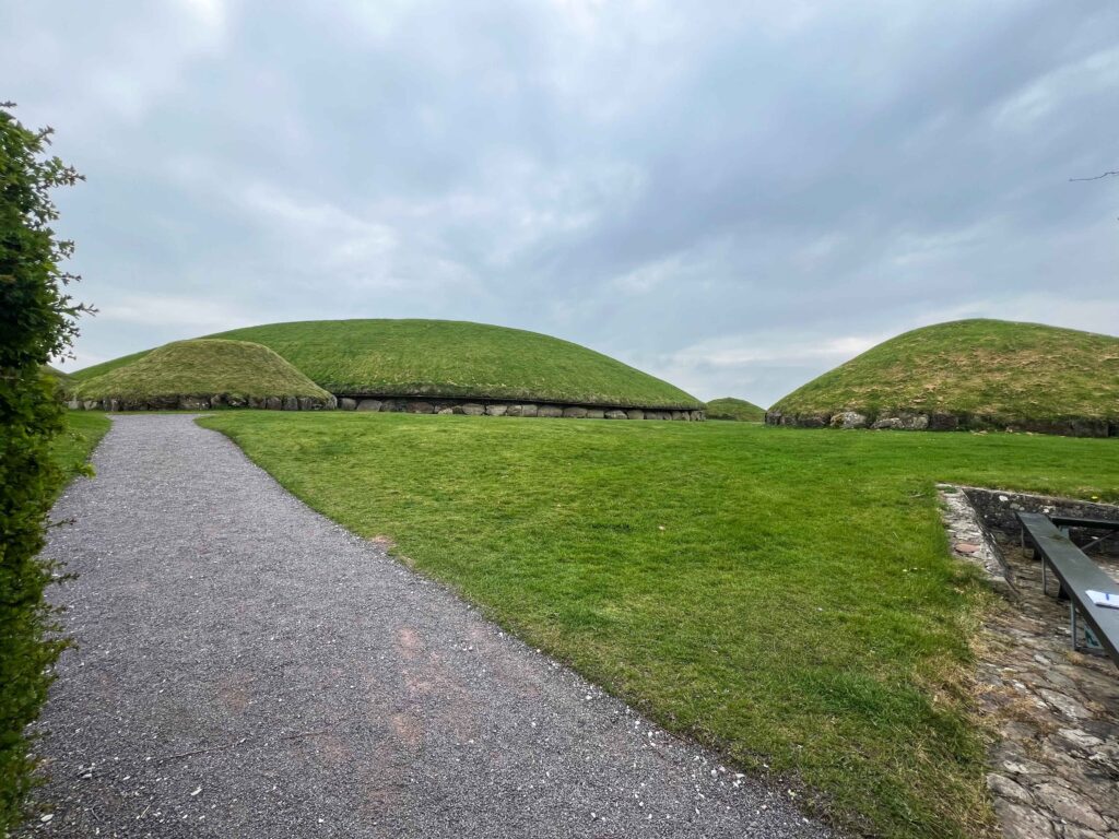 Large green mound with stone boulders around the bottom.