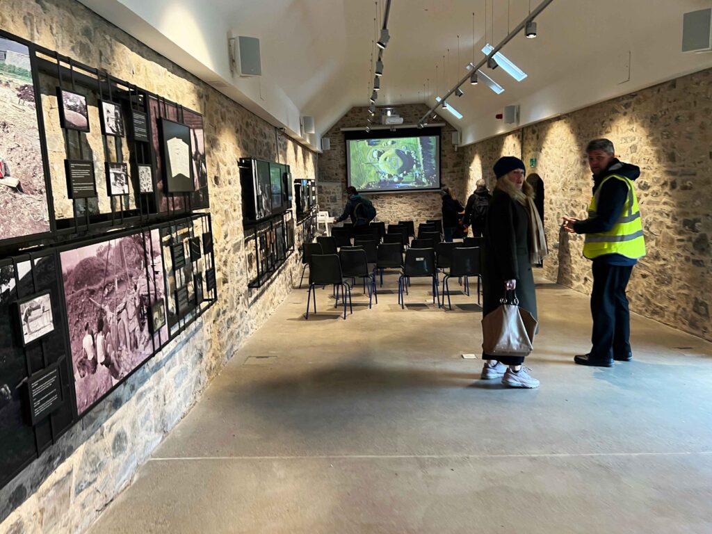 A room with stone walls and historical photos hanging.