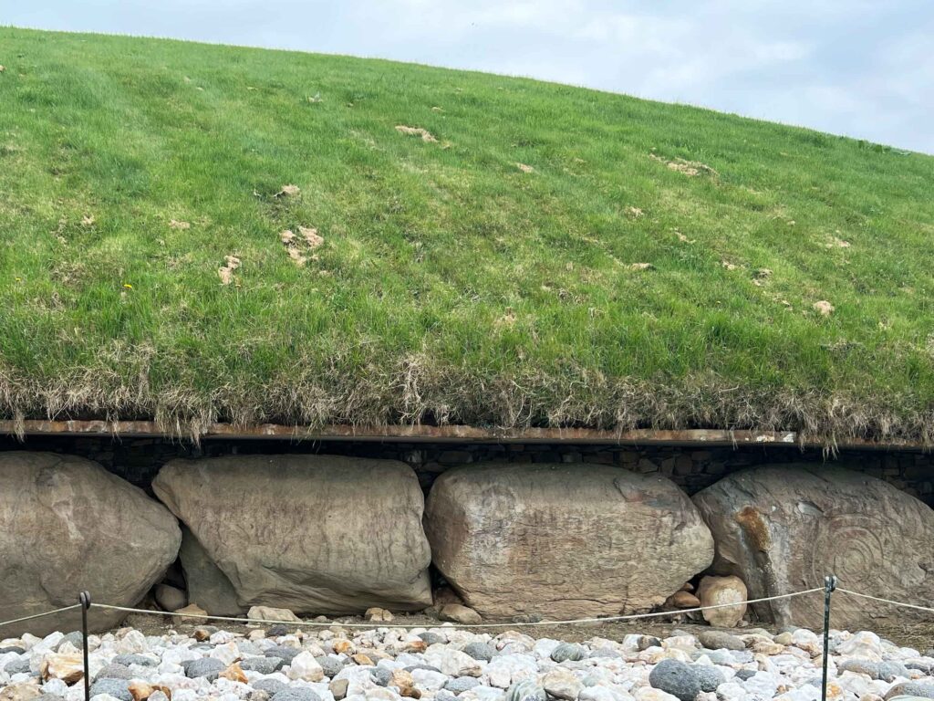 Large boulders surrounding base of green mound.