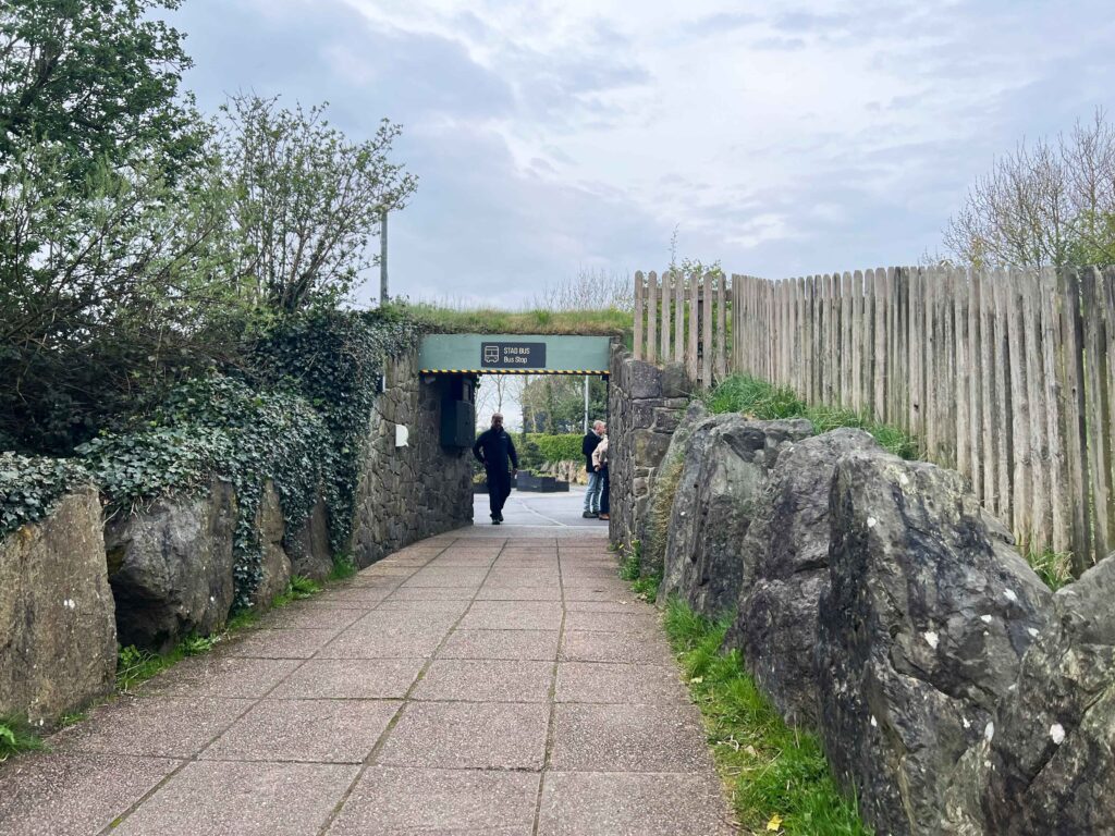 Walkway to a bus stop between large boulders.