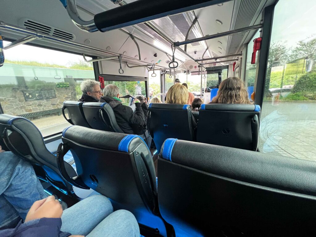 Inside a bus with passengers talking.