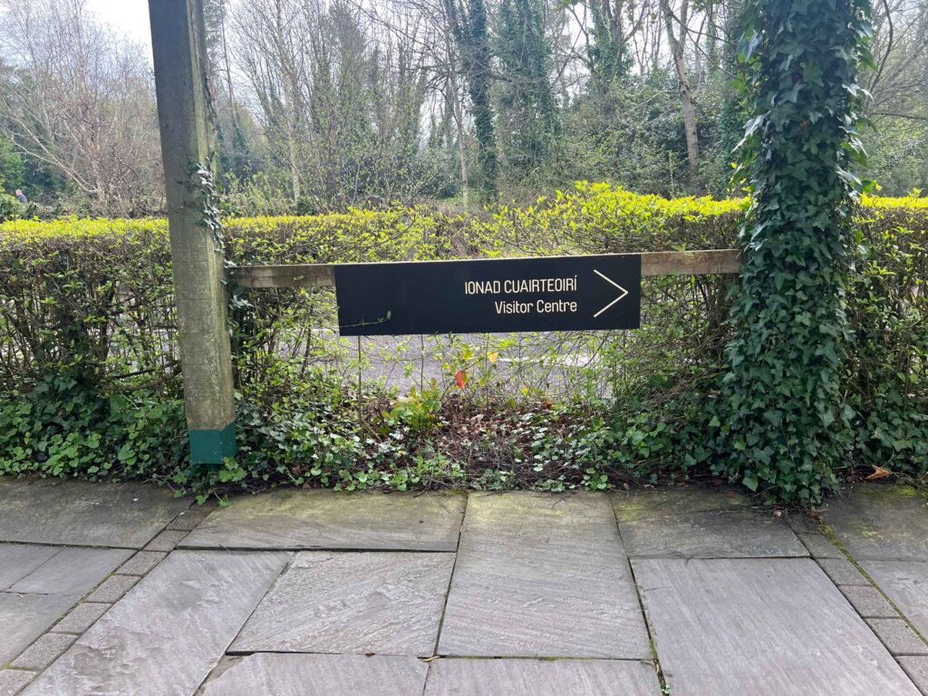 Sign indicating which way to walk to visitor centre at a museum.