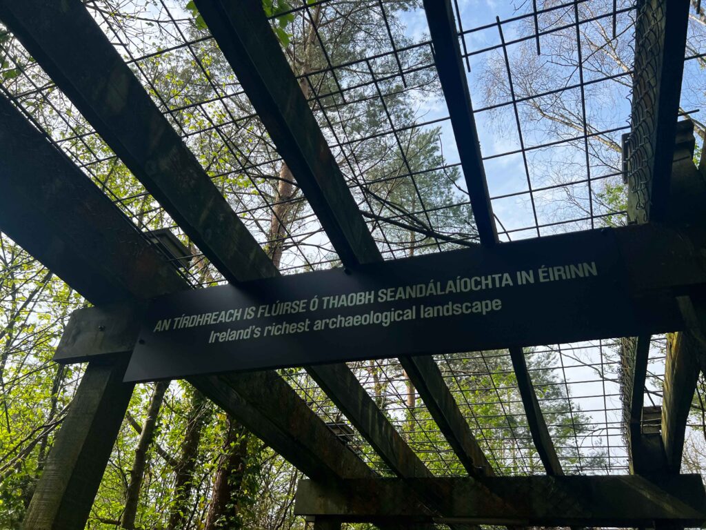 Wooden sign hanging from wooden trellis ceiling.