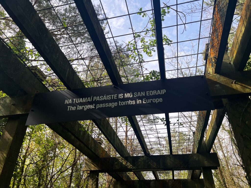 Wooden sign hanging from wooden trellis ceiling.