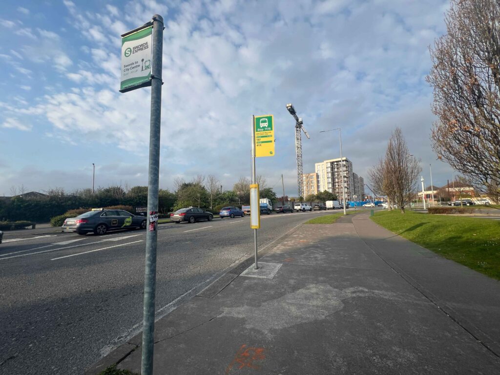 Bus stop signs on side of a road.