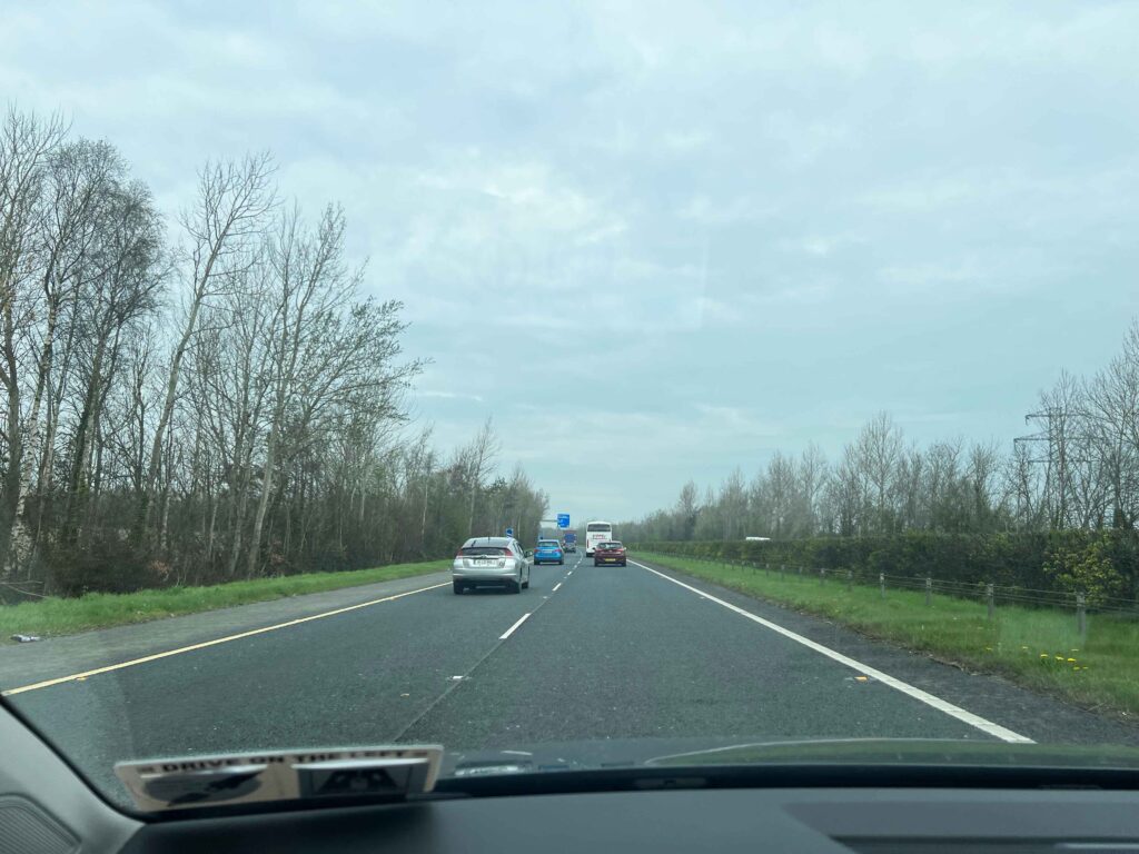 Cars driving on highway on a cloudy day.