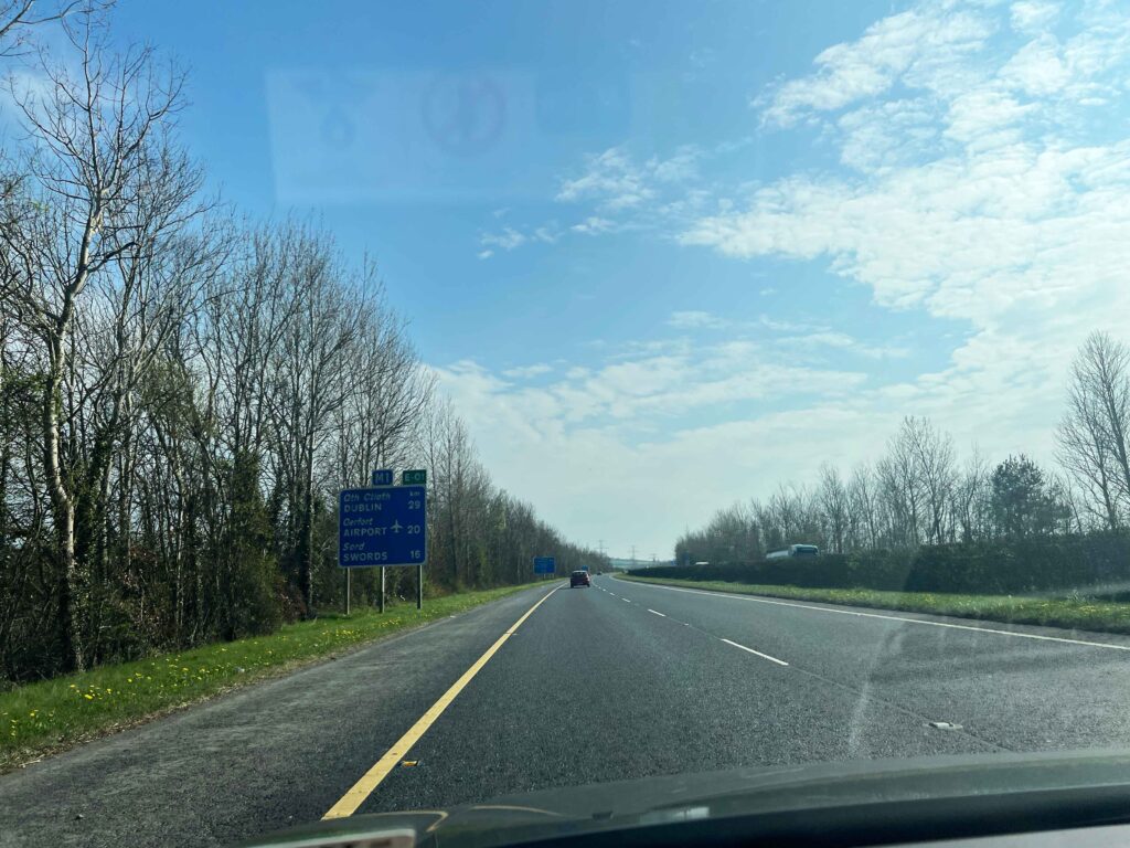 Almost empty highway with trees on roadside.