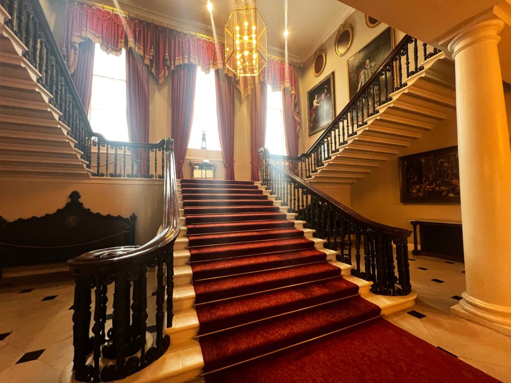 Stately staircase with red carpet inside Dublin Castle.