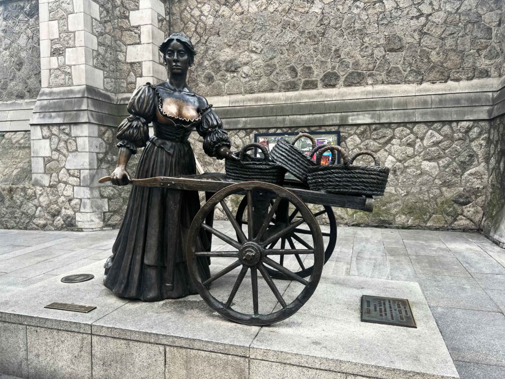 Iron statue of a maiden pushing a cart.