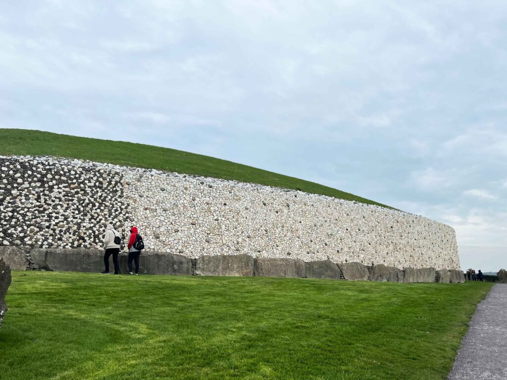 Large stone wall around grassy mound.