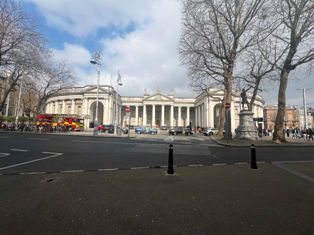 Greek colonial style white building on a street.