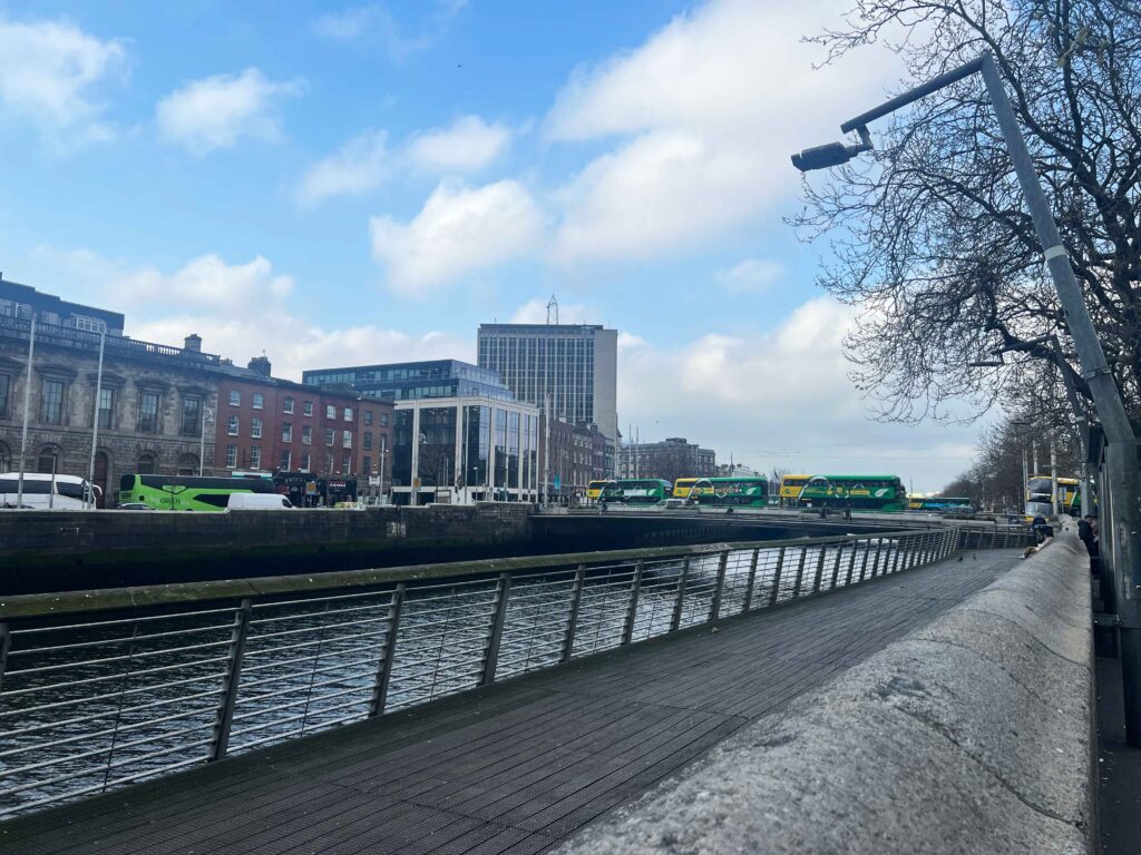 Looking down the quay in Dublin at a brideg lined with double decker buses.
