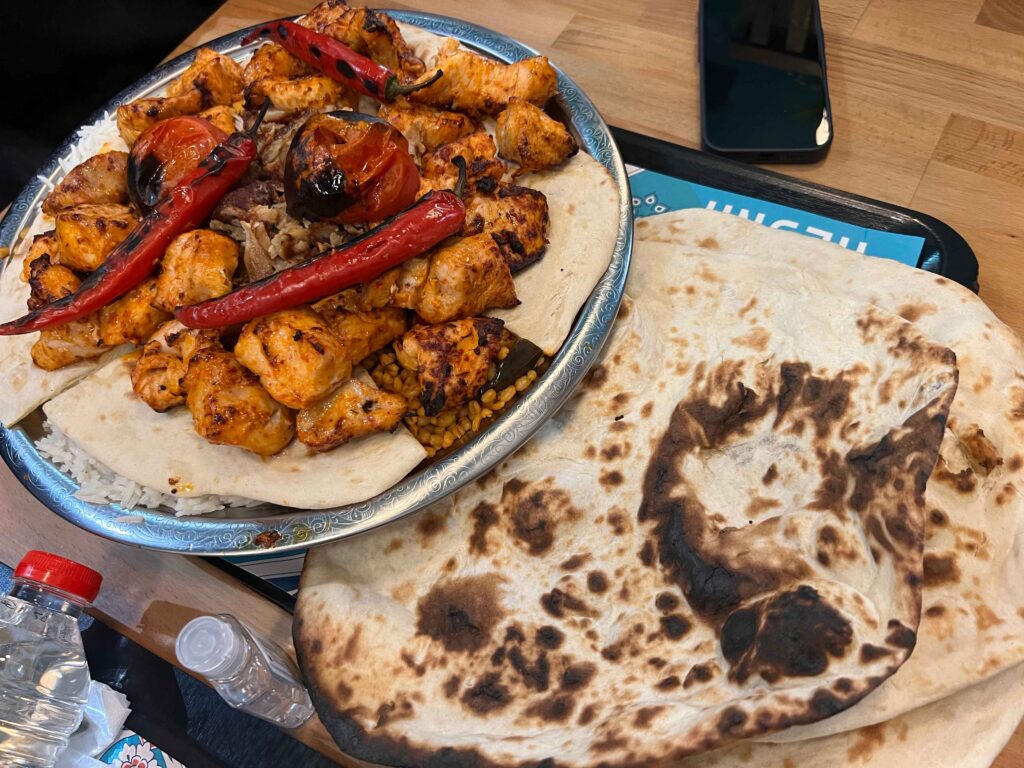 Chicken and peppers and pita on a plate in a restaurant you may visit on a stopover in Ireland.