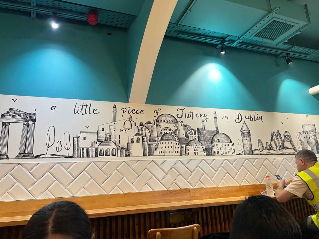 Blue wall with white and black sketched mural.