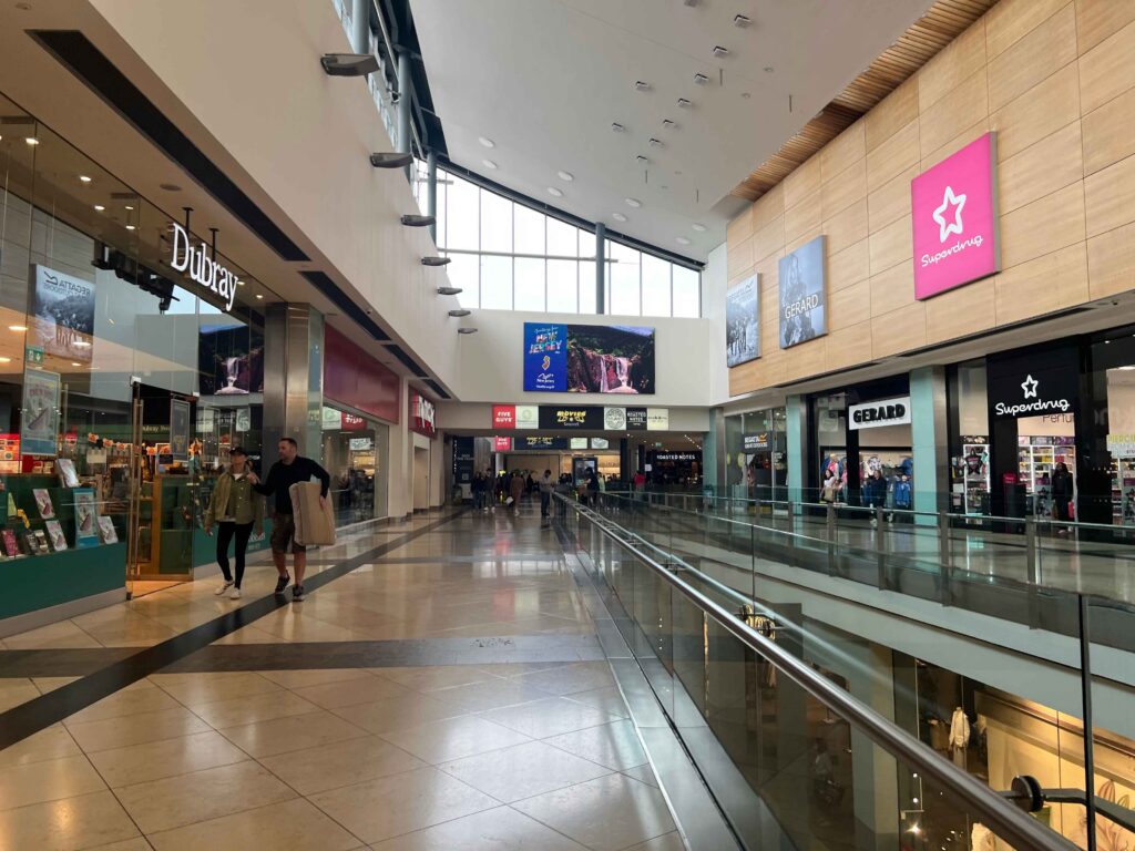Inside a shopping mall with people shopping.